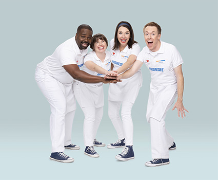 The Progressive Super Squad, consisting of Jamie, Flo, Alan, and Mara, pose with their hands stacked together for a cheer.